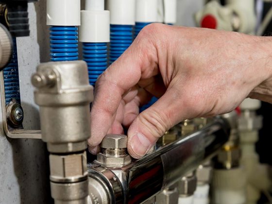 Eine Hand dreht an einem Ventil für Gas - Energiekosten