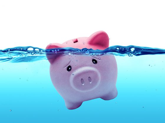 Ein Sparschwein schwimmt im Wasser und droht unterzugehen | Immobilie verkaufen