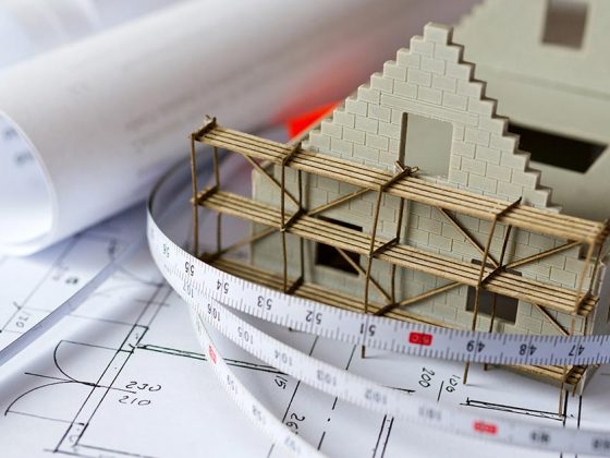 Collage aus Modellhaus, Maßband und Grundrissskizzen - Bauen oder Bestandsimmobilie?
