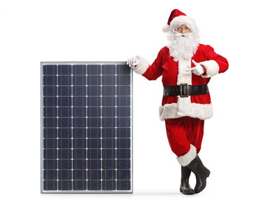 Ein Weihnachtsmann lehtn an einer Photovoltaikanlage - Weihnachtsgrüße