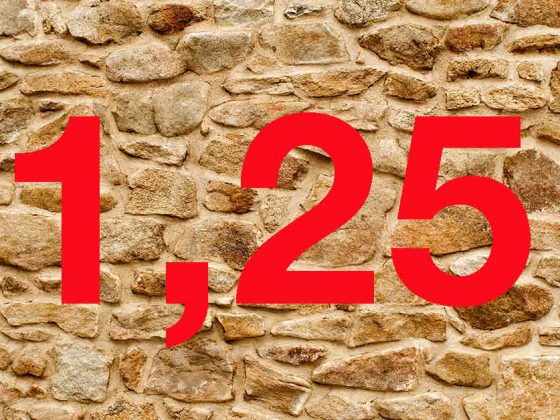Vor einer Natursteinmauer steht "1,25" in roten Zahlen | Baukredite