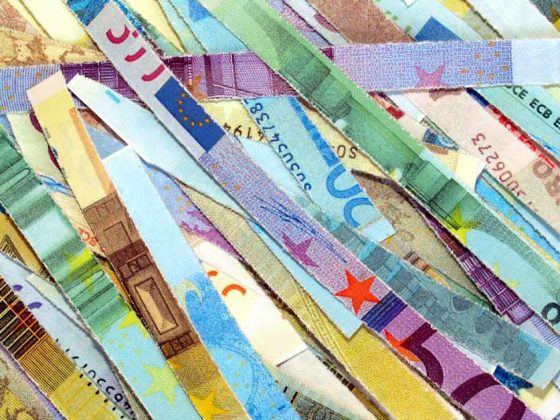In Streifen geschnittene, bunte Geldscheine