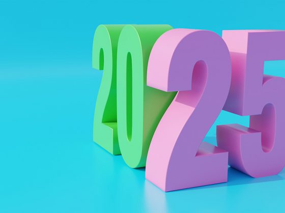 Auf einer hellblauen Fläche vor einem hellblauen Hintergrund stehen in einem Winkel zueinander, aber angelehnt eine grüne 20 und eine rosafarbene 25 | Immobilienmärkte 2025